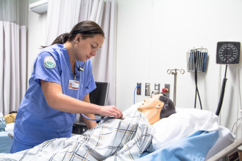 Sara Keatts demonstrates proper technique when checking a patient.