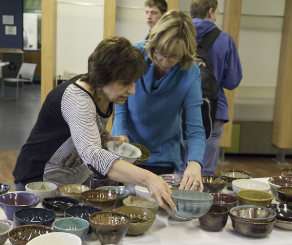 two ladies look at pottery bowls