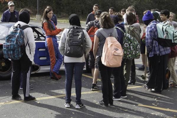 WCC students surround a race car.