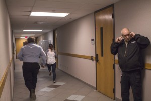 Students participating in the last scenario try to locate the nearest exits while the mock gunman is behind them.