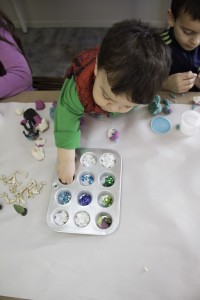 A child picks out decorations for his art project
