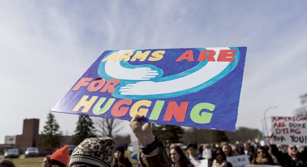 One of the many unique signs, reads “arms are for hugging.”