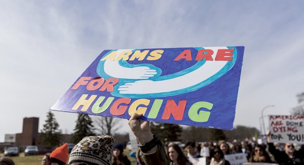 One of the many unique signs, reads “arms are for hugging.”