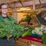 St. Joe employee Chloe Foreman purchases a healthy bunch of greens at the St. Joe's Farmers Market