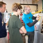 Advanced Manufacturing instructor Andy Dubuc (right) demonstrates how a Haas Automation machine works during Free College Day Sept. 30. Photo by Jennifer F. Sansbury