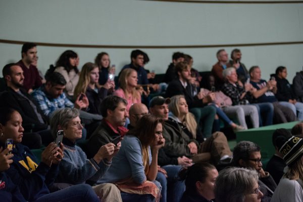 Members of the audience – some using phones to record the event – listen as Sanders and Whitmer speak in the 1,000-plus seat auditorium. Michael Govaere | Washtenaw Voice