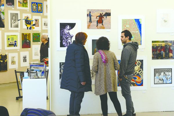 Visitors viewing the artwork of incarcerated artists at the Michigan League. Courtesy of the Prison Creative Arts Project.