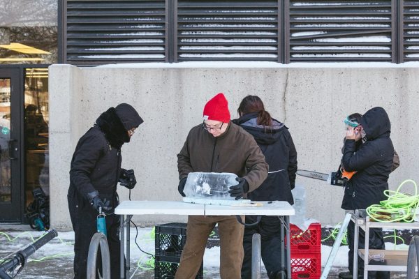 Chef Gary Marquardt (center) leads the first ever WCC ice carving class in creating a Pterodactyl. Danny Villalobos | Washtenaw Voice