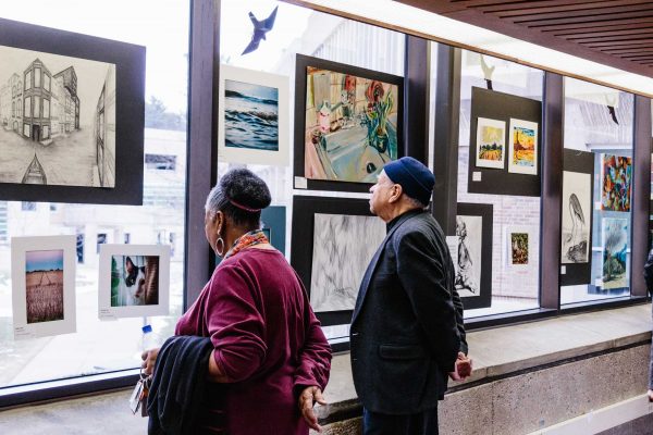 Spectators view the artwork at the Student Art Show opening that took place on March 7. Adeline Griffith | Washtenaw Voice