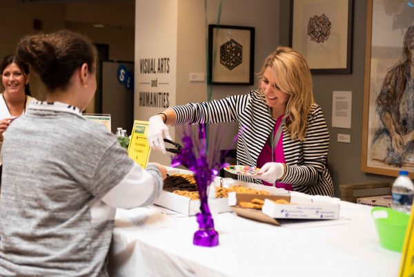 Carrie Mapes, a Personal Counselor distributes Insomnia Cookies to those attending the fair. Lily Meritt | Washtenaw Voice