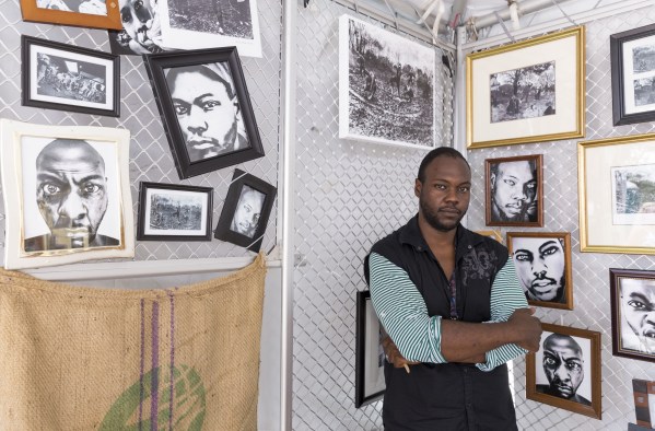 Jesse James Peterson III, a former WCC student, with his digital art at the 2017 Ann Arbor Art Fair. Washtenaw Voice File Photo