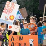 Community members of all ages attend the climate strike on University of Michigan’s campus with signs that bring awareness to climate changes. Eric Lee | Washtenaw Voice
