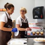 Candi Taylor and Patty Berry, employees at the Sweet Spot pack baked goods prepared by WCC culinary students. Lily Merritt | Washtenaw Voice