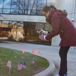 Jessica Ponce-Torres, technical assistant for Student Development, sets up flags outside of the Student Center in honor of Veterans Day. Lilly Kujawski | Washtenaw Community College