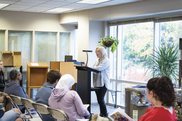 K.D. Williams, an English instructor at WCC, shares a poem at the “Inner and Outer Spaces” poetry reading. Lilly Kujawski | Washtenaw Voice