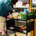 Bethany Kennedy setting a basket of toiletries in the snack pantry. Torrence Williams | Washtenaw Voice