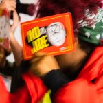 Protester from the Sunrise Movement demanding support of the Green New Deal is Iescorted out of Joe Biden's rally by police.