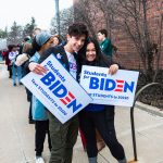 Liam Richichi and Amelie Winstel, both 17-year-old juniors at Northville High School hold "Students for Biden" signs outside Renaissance High School in Detroit as they wait to enter for presidential candidate Joe Biden's Monday night rally.