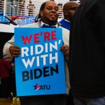 RiChard Jackson of Grand Rapids holds a "We're Ridin' With Biden" poster at the Monday night Biden rally in Detroit. Jackson said he likes Biden for his "good track record."