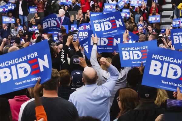 Supporters of presidential candidate and former Vice President Joe Biden wave signs and posters as Biden speaks during his Monday night rally in Detroit.