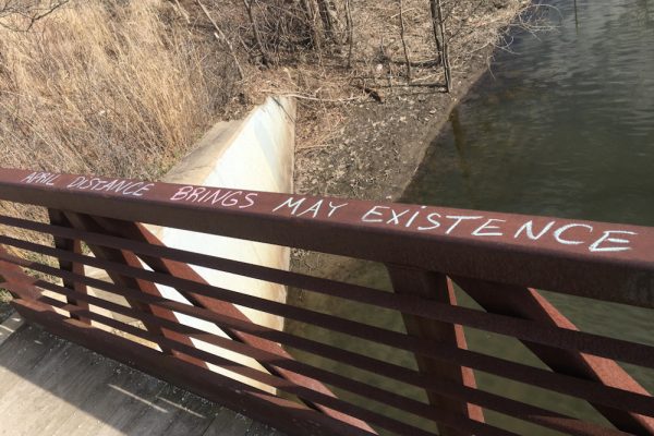 A park visitor wrote “April distance brings May existence” on the bridge at Mary Beth Doyle park to encourage social distancing. Lilly Kujawski  | Washtenaw Voice