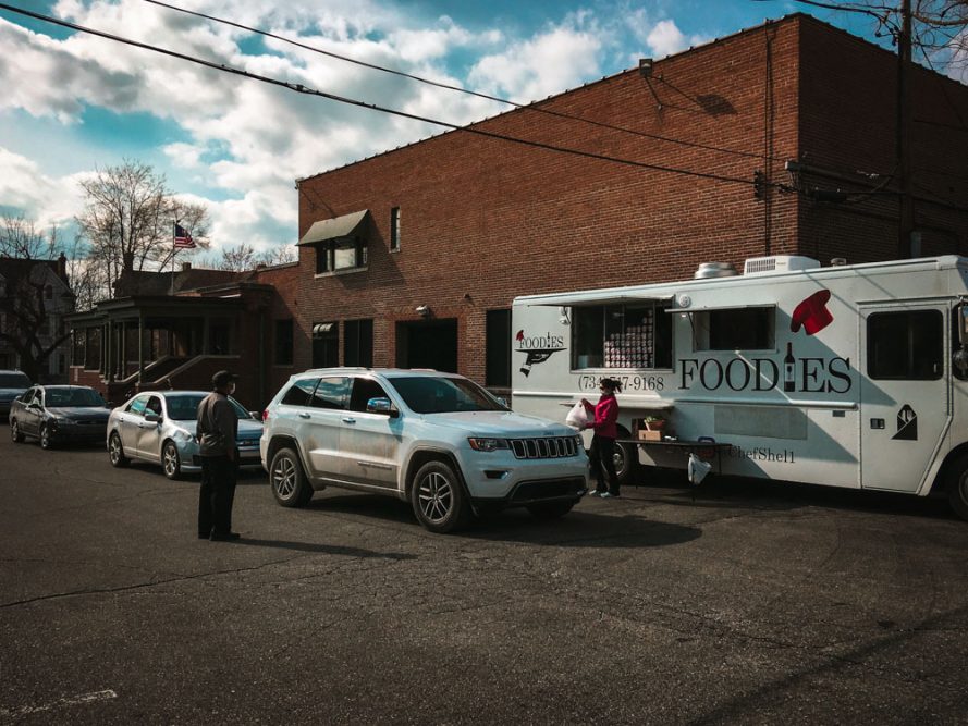 Cars wait to pick up meals from the Foodies food truck. The local catering company started handing out free food in late March to help residents impacted financially by COVID-19.