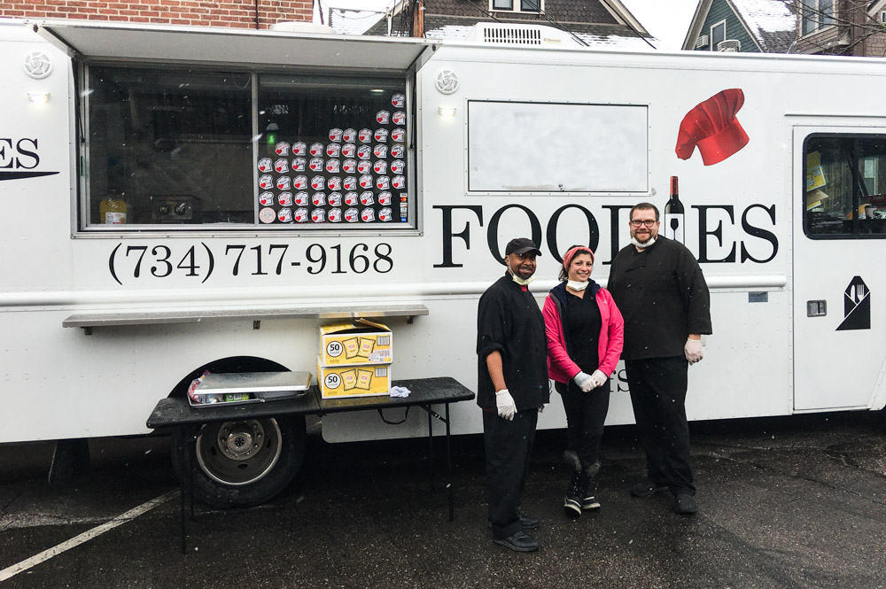 Foodies workers pose in front of the catering company's food truck. The local company has been passing out free meals to help residents impacted by COVID-19. 