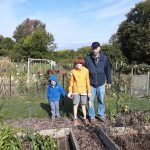From left to right: sons Lucian, four, Pascal, 11, and father Dan Crane in their garden plot. Debra Destefani | Washtenaw Voice