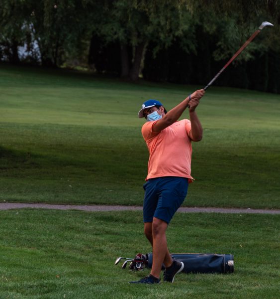 Jorge DiGiovanni takes a swing while wearing a mask. Torrence Williams | Washtenaw Voice