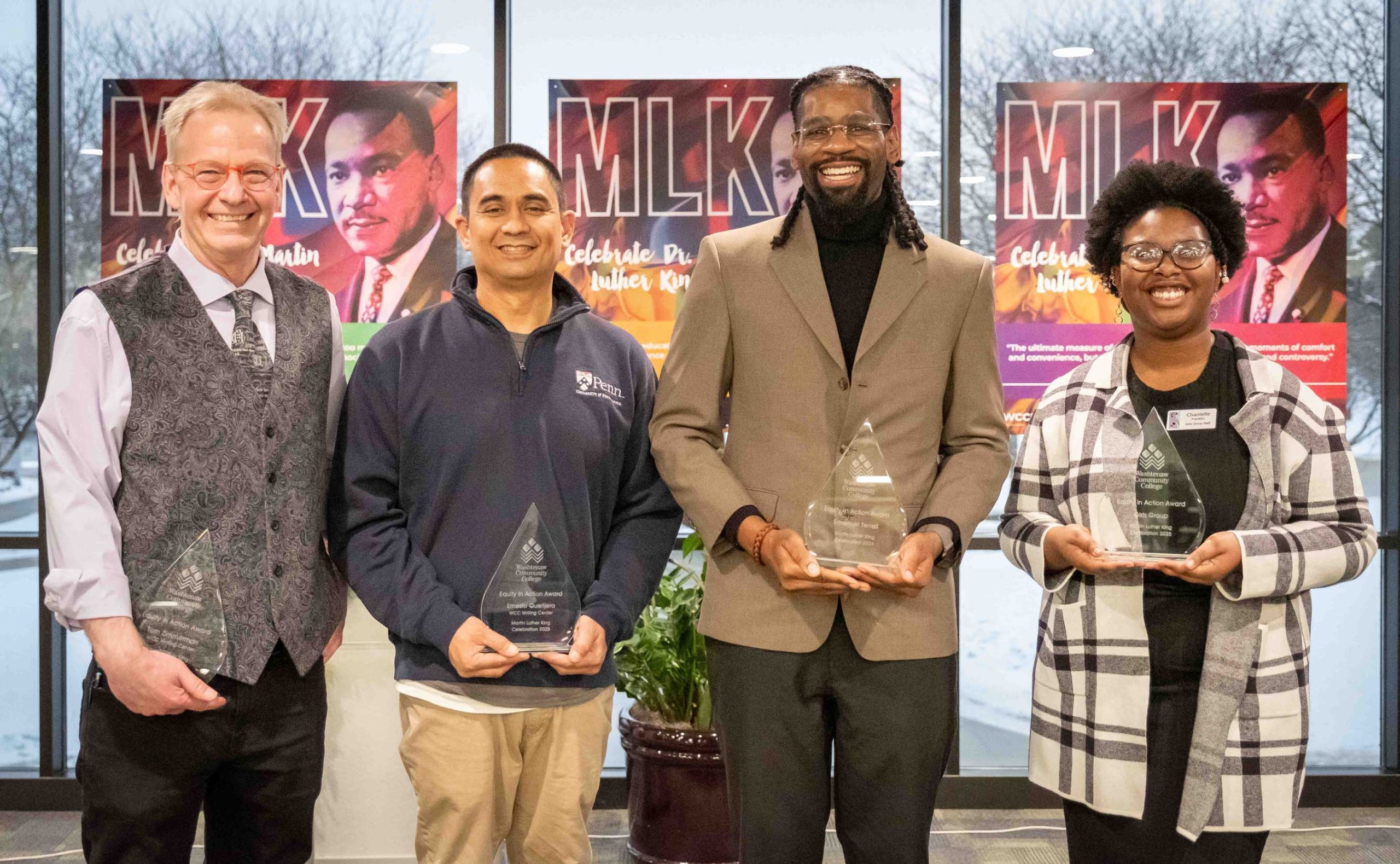 The four Equity in Action award winners stand in a line while smiling and holding their trophies