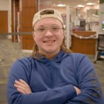 headshot of Reiker Marowelli from the shoulders up crossing arms and smiling