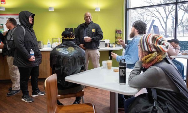 A group of four students gather and listen to Deputy Chief Derran Shelby speak.