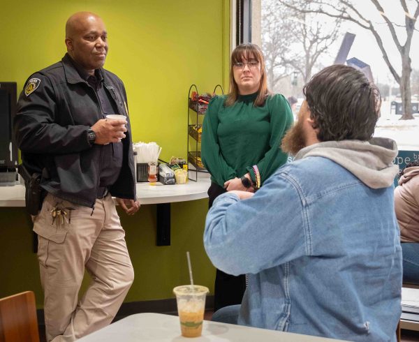A student turns away from the camera to speak with Deputy Chief Derran Shelby.