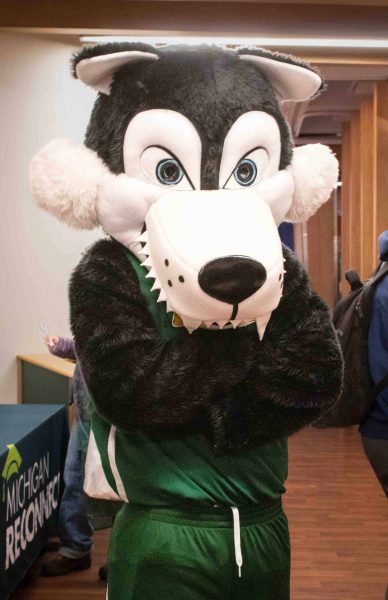 A person wearing WCC's wolf mascot costume, Alpha, is pictured standing with arms crossed.
