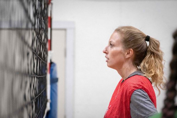 Reese Page stands in front of the volleyball net and waits for the ball.