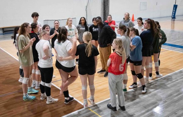 The group huddles around Coach Isaac London and listens to his encouraging words.