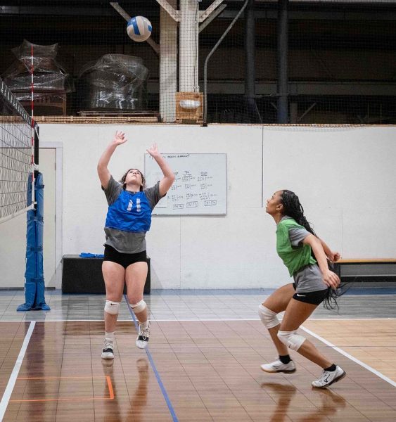 Natalie Leffler sets the volleyball to teammate Sasha Swasey.
