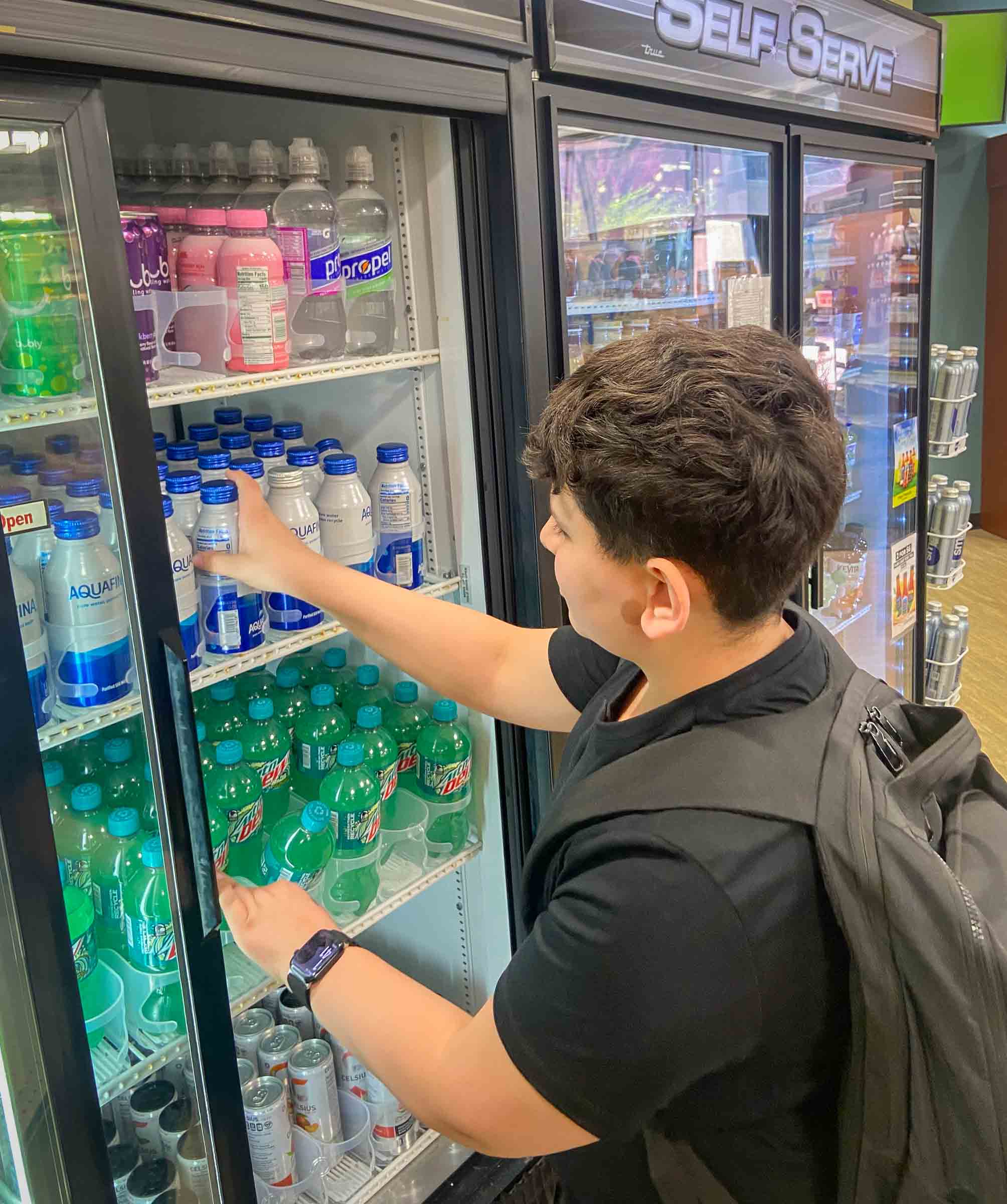Talal Baker grabs a metal bottle of Aquafina water from a self-serve water cooler.