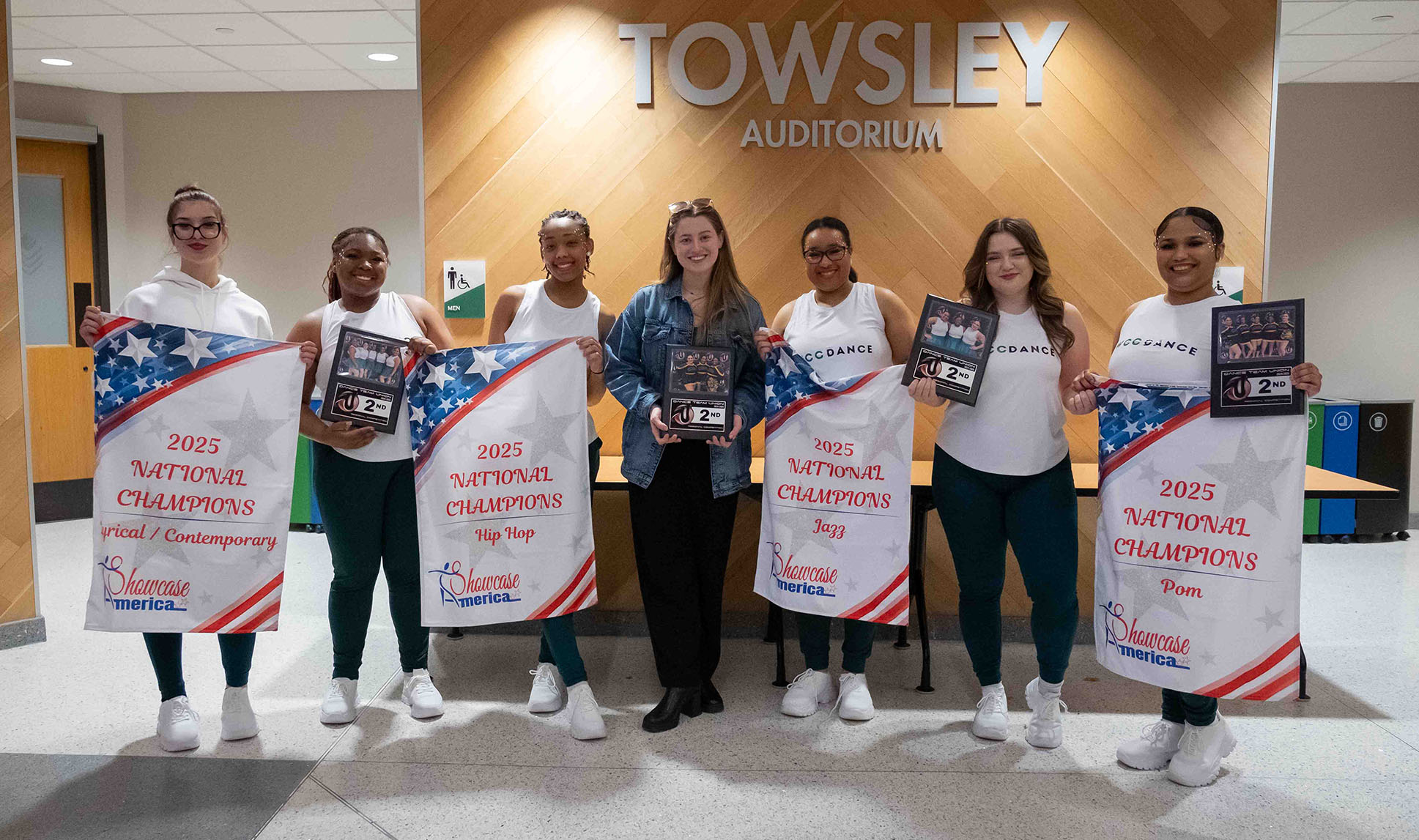Group photo of the WCC Dance Team smiling and holding the awards they won at the competition.