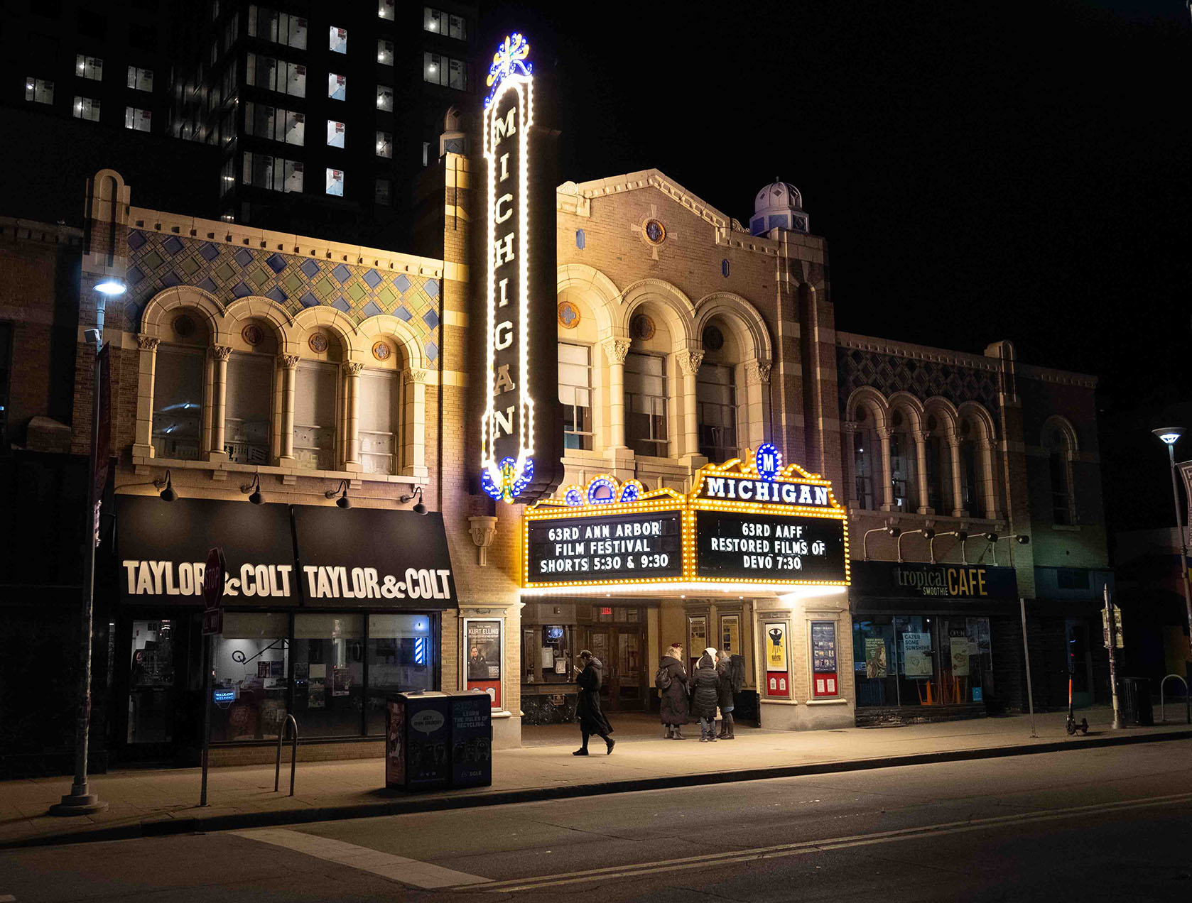 The Michigan Theatre is shown at night with a brightly lit sign advertising the Ann Arbor Film Festival.