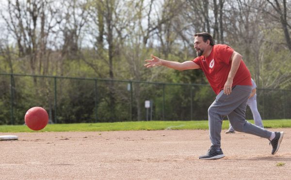 Rich Rezler is shown bending forward with an arm outstretched after releasing the kickball from his hand.