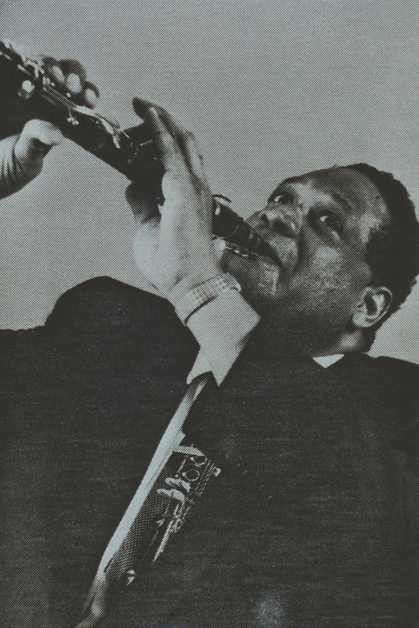 An archival black and white image of Morris J. Lawrence playing the clarinet.